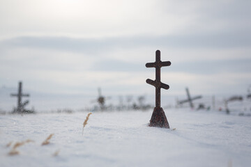 Orthodox cross on a snow-covered grave in the cemetery of an abandoned Arctic village Shakhtyorsky...