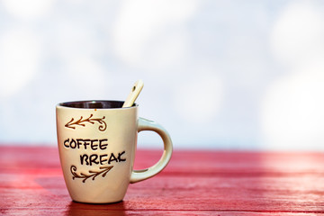 Cup of creamy homemade expresso coffee on red wooden board.
