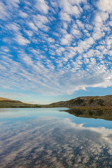 clouds reflected in lake Rondvatnet in Rondane National Park Norway