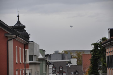 a zeppelin airship flying over central Bregenz, Lake Constance region, Voralberg, Austria © Simo