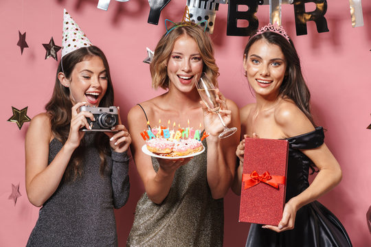 Image of alluring party girls holding birthday cake and gift box