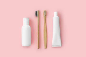 Set of eco-friendly toothbrushes, toothpaste and other tools on pink background. Dental and healthcare concept. Top view, flat lay.