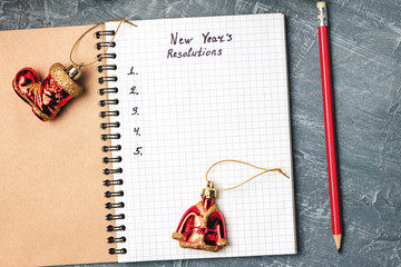 New Year's resolution, text in notepad, promises concept, pencil, decorations on dark background,...