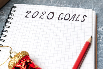 2020 goals, text on the paper in notepad, close up view New Year promises concept