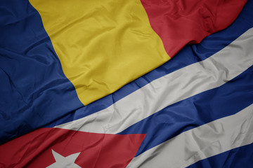 Fototapeta premium waving colorful flag of cuba and national flag of romania.