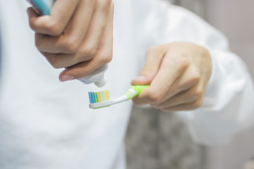 hand with toothbrush and toothpaste