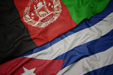 waving colorful flag of cuba and national flag of afghanistan.