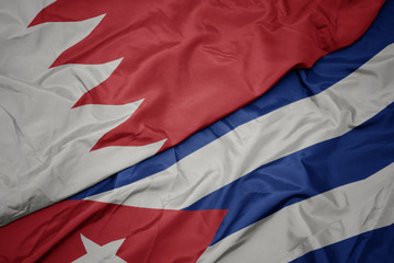 waving colorful flag of cuba and national flag of bahrain.