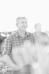 Black and white photo of farmer standing in field