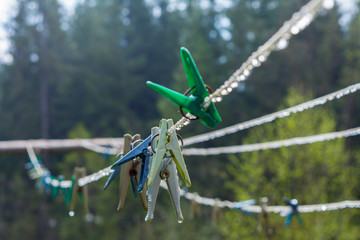 plastic clothesline with clothespin and dew drops on closeup. © Vladyslav