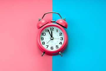 pink rustic alarm clock on pink blue background