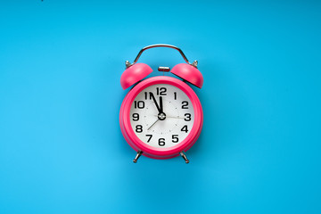 pink rustic alarm clock on blue background