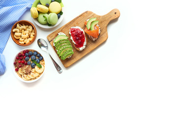 breakfast top view isolate white background. oatmeal with berries, toasts on a wooden tray, nuts, coffee