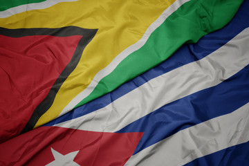 waving colorful flag of cuba and national flag of guyana.