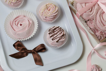 Aerial pink cherry marshmallows. Different shapes and sizes. Sprinkled with dextrose. Garnished with Chocolate.