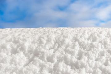 White snow on a background of blue winter sky. Copy space, blank for a design idea. The concept of a festive Christmas mood.