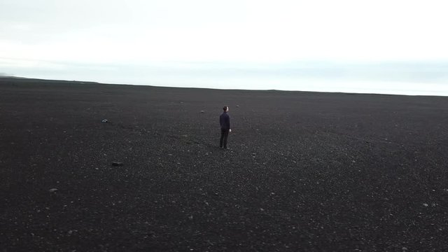 freedom and challenge concept, loneliness, man standing alone in remote desert, camera rotating around