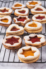 Flat lay with christmas cookies on marble surface with christmas decorative pine branch, jam, gift and cookie cutters