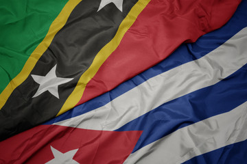 waving colorful flag of cuba and national flag of saint kitts and nevis.