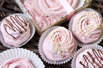 Aerial pink cherry marshmallows. In a gift box with a transparent cover. Near the marshmallows without packaging. Against the background of wicker vines.