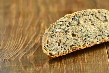 Homemade whole grain bread with seeds on a wooden background, copy space