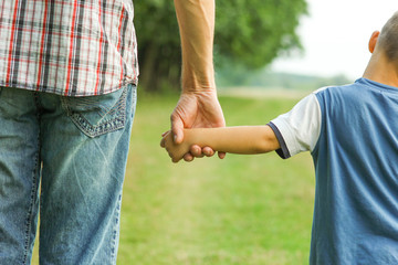 the parent holds the hand of a l child