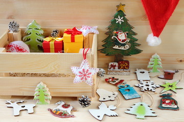 Still life from bright Christmas and New Year decorations and crate. Composition of bright Christmas and New Year decorations made of plywood and fabric on a wooden background.