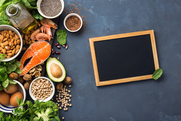 Empty chalkboard for your text with Food sources of omega 3 and healthy fats. Foods high in fatty acids including vegetables, seafood, nut and seeds