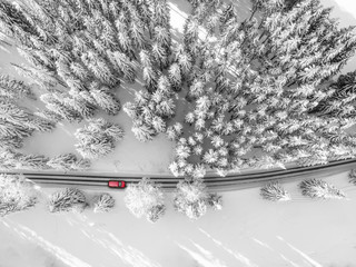 Road to nowhere. A car driving through a snowy road.