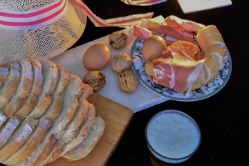 three nuts surrounded by serrano ham bread eggs and a beer