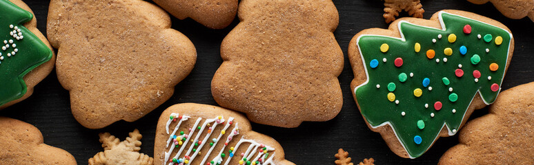 tasty glazed Christmas cookies on black background, panoramic shot