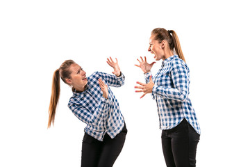 Young handsome woman arguing with herself on white studio background. Concept of human emotions,...