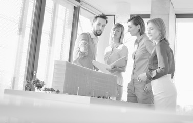 Fototapeta na wymiar Black and white photo of business people discussing on new building structure plan in office