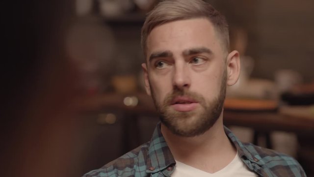 Handheld shot of man with beard having conversation with someone