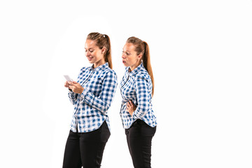 Young handsome woman arguing with herself on white studio background. Concept of human emotions, expression, mental issues, internal conflict, split personality. Half-length portrait. Negative space.