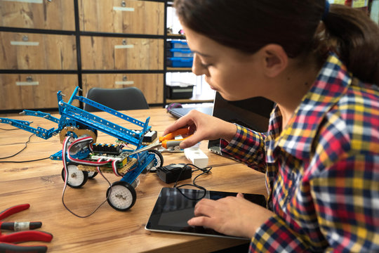 Young woman engineer working on robotics project. Startup concept