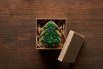 top view of Christmas tree cookie in gift box on wooden table