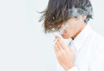 A close-up of a young man who smokes on a white background