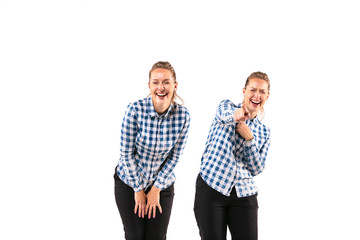 Young handsome woman laughting with herself on white studio background. Concept of human emotions,...