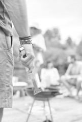 Man using bellows for preparing food in barbecue grill with friends on pier