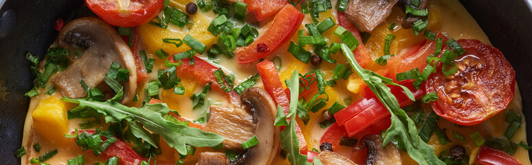 top view of yummy homemade omelet with mushrooms, tomatoes and greens