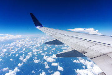 Fototapeta premium Clouds and airplane wing seen from window