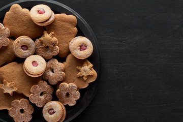top view of Christmas cookies in pan on black wooden table with copy space