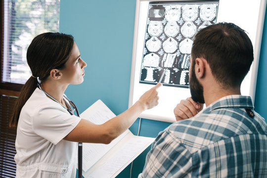 Image of female doctor and patient man looking at x-ray scan in hospital