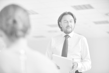 Mature businessman brainstorming colleagues at new office