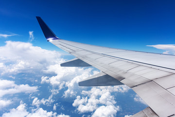 Clouds and airplane wing seen  from window