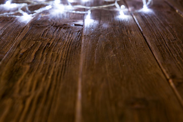 Glowing bokeh background with empty wooden table. Christmas background