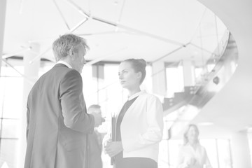 Black and white photo of Businessman and young businesswoman discussing at new office