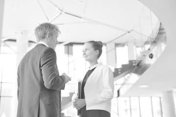 Black and white photo of Businessman and young businesswoman discussing at new office