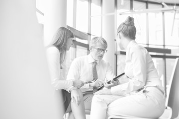 Fototapeta premium Black and white photo of Business colleagues planning strategy over document during meeting at office